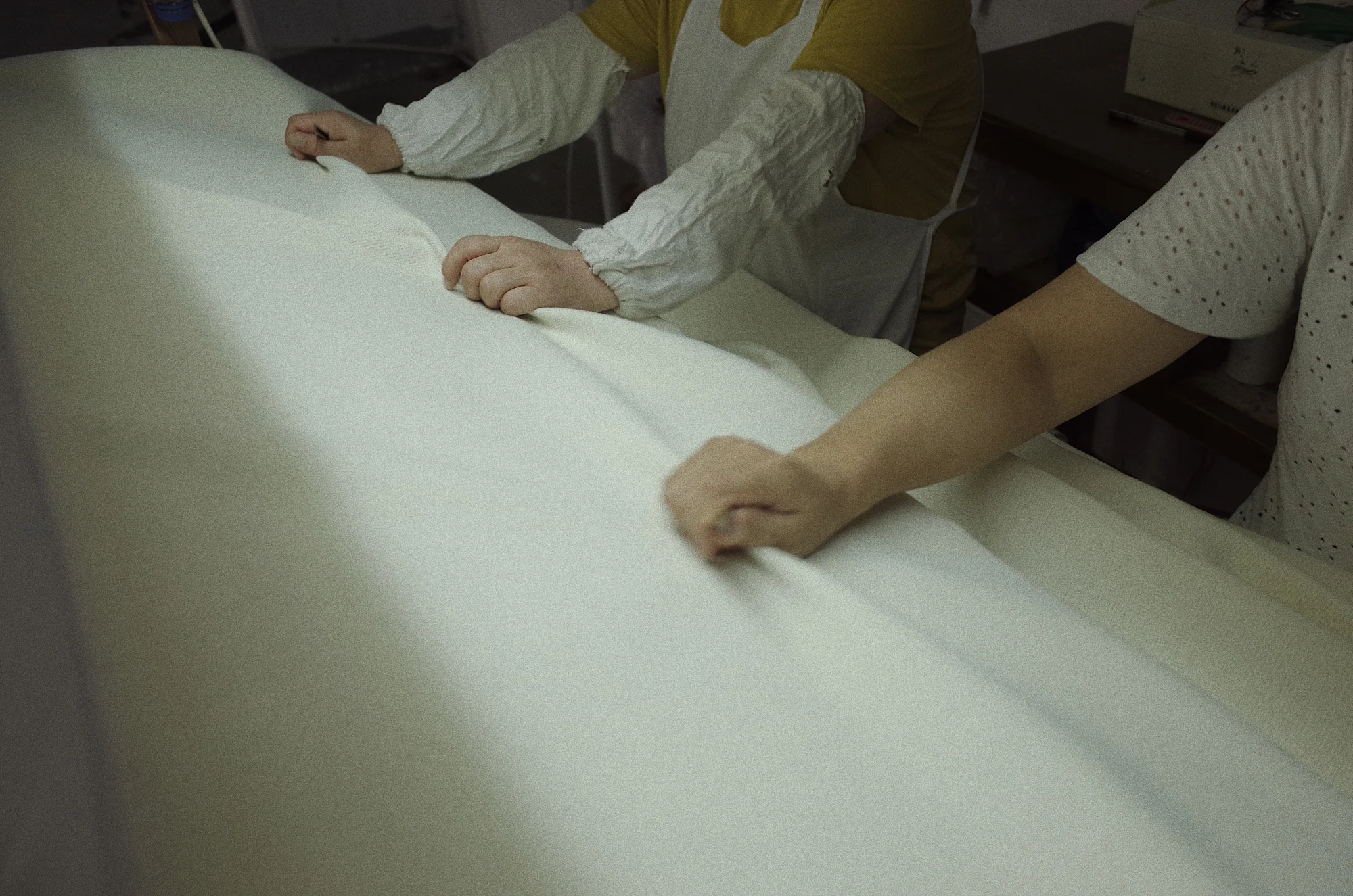 Fred Textile team performing a handfeel and surface inspection on finished fabric
