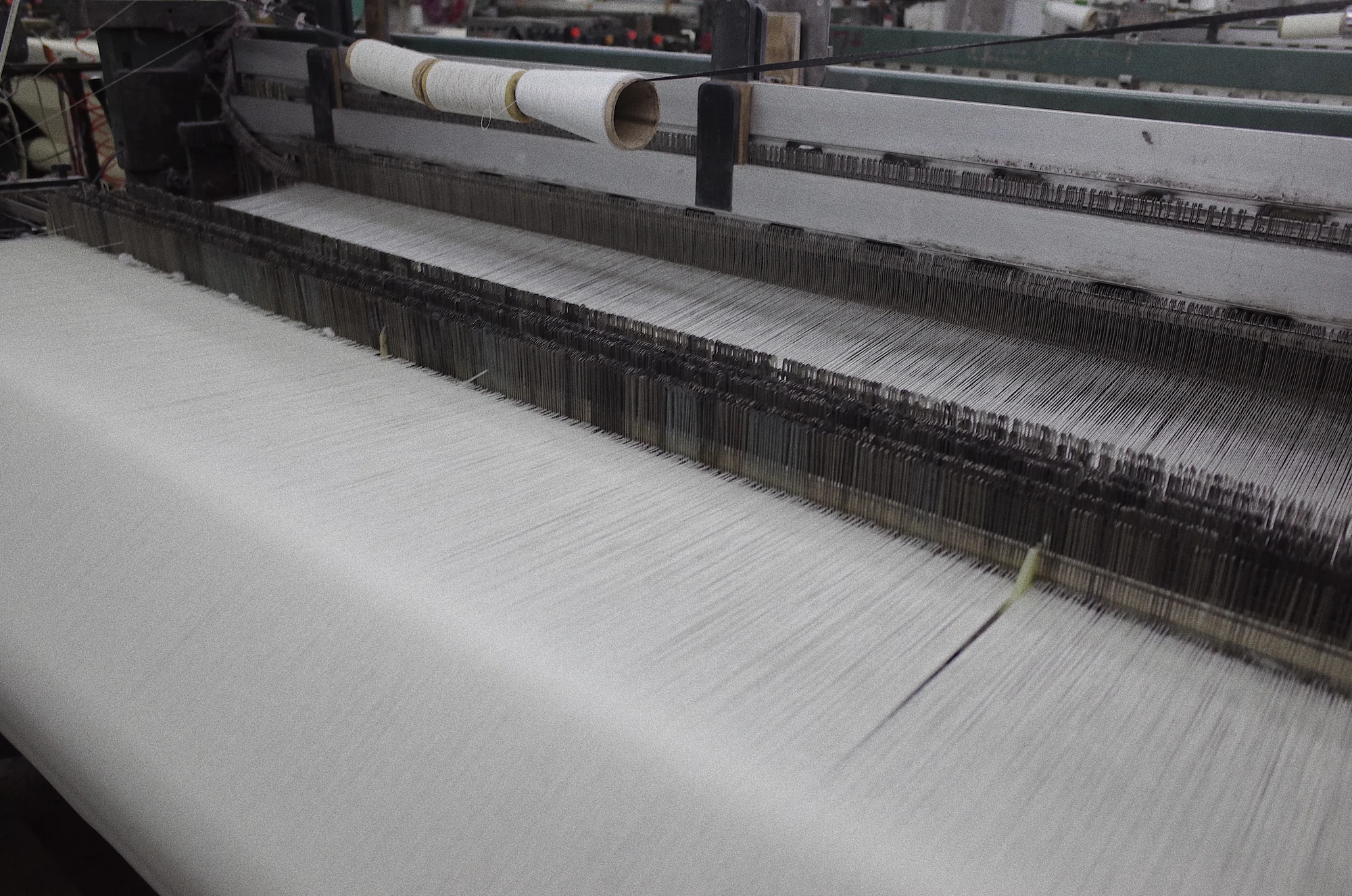 Fred Textile loom weaving a light-coloured woven fabric